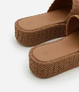 Sandalia flatform con superficie trenzada metalizada color dorado, sin cierre, con tira ancha y puntera redonda.