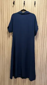 Vestido midi azul marino con cuello camisero, mangas cortas con dobladillo y abotonadura frontal completa.