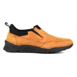 Zapato de vestir negro, tipo mocasín, sin cordones, con elásticos laterales y suela gruesa.