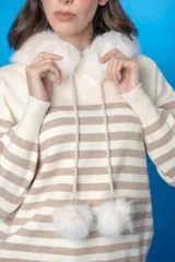 Sweater con capucha a rayas horizontales blancas y negras, con cuello de piel sintética negra y cordón de perlas con pompones de piel sintética negra.