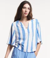 Blusa amplia de viscosa con rayas verticales irregulares en blanco y celeste. Tiene mangas cortas evasé, escote en pico con detalle de abalorio.