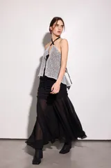 Falda larga de gasa negra con forrería en la parte de las caderas, con frunces y largo godet.