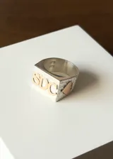 Anillo de plata 950 con apliques de oro 10k, con forma de sello y grabado de las iniciales SDC.