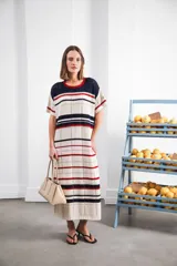 Vestido largo de tejido calado con rayas horizontales en color crudo, azul marino y rojo. Tiene tajo lateral y logo bordado en la manga.