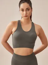 Top deportivo gris oscuro con espalda deportiva y banda elástica en el bajo busto.