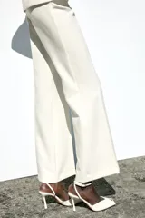 Pantalón largo de vestir color blanco, de tiro medio y corte flare.
