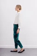 Pantalón babucha verde esmeralda de terciopelo con elástico en la botamanga, bolsillos plaqué en el frente con remaches metálicos y bolsillos cargo en las piernas.
