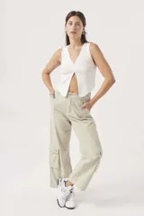 Pantalón cargo color verde claro, de corte ancho y tiro alto, con bolsillos laterales con fuelle y cierre con botón y cremallera.