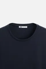 Camiseta slim fit de cuello redondo y manga corta, confeccionada en tejido de algodón con elasticidad.