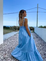 Maxi vestido celeste de jean con breteles regulables y bolsillos laterales.