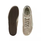 Zapatilla Puma de perfil bajo, estilo automovilismo, color beige/marrón claro con detalles en blanco. Presenta una capellada de gamuza, la icónica franja Puma en un tono más claro y suela de goma marrón oscuro.
