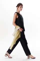 Top sin mangas negro con escote en V y costuras blancas visibles.