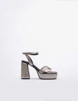 Sandalias de plataforma color plateado con tiras cruzadas y tobillera con hebilla.