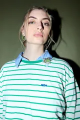 Remera de algodón blanca con rayas horizontales verdes, cuello redondo y logo bordado en azul en el pecho.