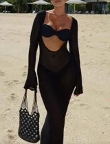 Vestido largo de tejido de punto calado color negro, con mangas largas y corte ajustado.