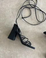 Sandalias negras con tiras finas y taco aguja de 9 cm.
