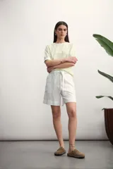 Short de vestir blanco, tiro alto, con pliegues frontales y lazo para ajustar en la cintura.