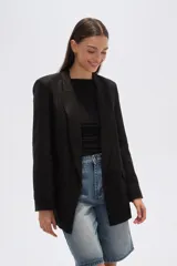 Blazer color beige, de corte holgado, con solapas anchas y bolsillos frontales.