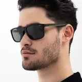 Lentes de sol INVU con montura rectangular negra mate y lentes polarizadas grises. Patillas negras con interior verde oliva.