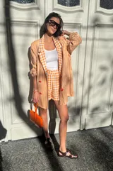 Short de lino a cuadros color naranja y blanco, estilo sastrero con calce holgado.