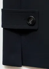 Vestido corto azul marino, sin mangas, con cuello redondo, corte recto, cierre trasero invisible, aberturas laterales en el ruedo y botones decorativos en la parte inferior.