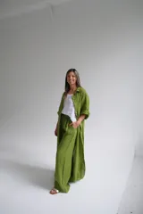 Vestido camisero largo color verde oliva, de lino italiano, con cuello camisero, mangas largas con puños abotonados y cierre frontal con botones. Tiene corte recto y fluido.