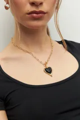 Collar dorado con cadena de eslabones y dije de corazón negro con borde dorado.