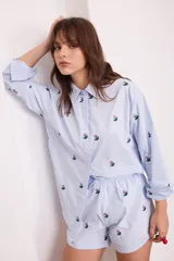 Short negro con bordado de flores rosas, con elástico en la cintura y cordón ajustable.