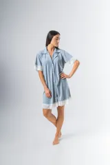 Camisa celeste con estampado a rayas verticales, de corte recto, con cuello camisero, cierre frontal con botones, mangas cortas con detalle de puntilla y ruedo con puntilla.