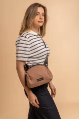 Bandolera pequeña de tela negra, con correa ancha ajustable y cierre superior.