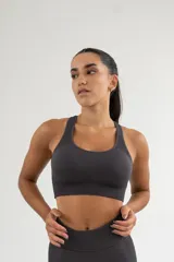 Top deportivo gris con breteles anchos y espalda deportiva.