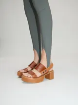 Sandalias de cuero color marrón con plataforma y taco cuadrado. Tienen dos tiras anchas sobre el empeine y una correa trasera con elástico.