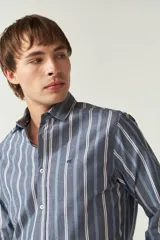 Camisa de manga larga a rayas verticales azules y blancas, corte slim fit y logo bordado en el pecho. Confeccionada en algodón.