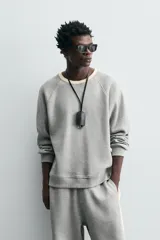 Sudadera gris de tejido compacto con mezcla de algodón y viscosa, corte relaxed fit, cuello redondo con rib combinado a contraste, manga larga y acabados en rib.