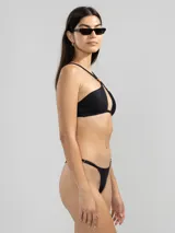 Conjunto de bikini negro con top halter con abertura en el centro y detalle de aro dorado.