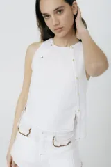 Musculosa blanca con cuello redondo y botones dorados en los laterales.