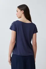 Blusa azul marino con estampado floral en blanco y ocre, de corte recto y mangas cortas.