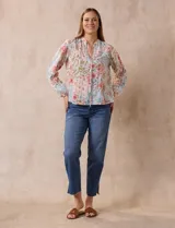 Blusa de gasa plisada estampada con flores azules, marca Floral & Ivy. Cuello a la base, escote en V y lazo de ajuste.