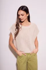 Chaleco de punto calado color beige, con cuello redondo y sisas amplias.
