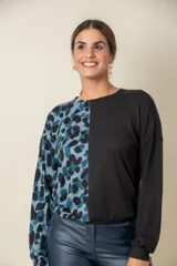 Buzo de manga larga, con una mitad en color liso negro y la otra mitad con estampado animal print en tonos azules y negros.