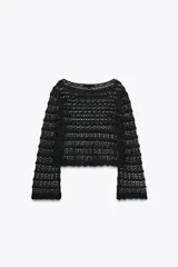Jersey corto de punto calado negro, con cuello redondo amplio y mangas largas acampanadas.