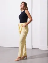 Pantalón de lino color amarillo con pretina ancha, pasadores y lazo de ajuste.