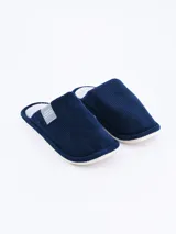 Pantuflas cerradas de tela color azul marino con suela blanca.