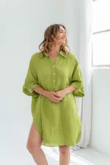 Vestido blanco de lino, corte holgado, con cuello camisero, mangas 3/4 y aberturas laterales.