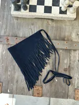 Faja negra de gamuza con flecos largos y tiras finas para atar a la cintura.