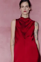 Vestido midi rojo de satén con cuello alto y sisas amplias. Cierre en la espalda con abertura y botones.