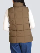 Chaleco marrón con relleno, cierre frontal con cremallera dorada, cuello alto y bolsillos laterales con cremallera.
