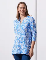 Blusa amarilla estampada con motivos florales en blanco, escote en V y mangas tres cuartos.