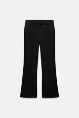 Pantalón negro de tiro alto con trabillas en la cintura, bolsillos delanteros y traseros, raya planchada en el frente, pierna recta y bajo acampanado.