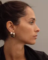 Aros pequeños de bronce con forma irregular y acabado liso, estilo huggie o argolla gruesa.